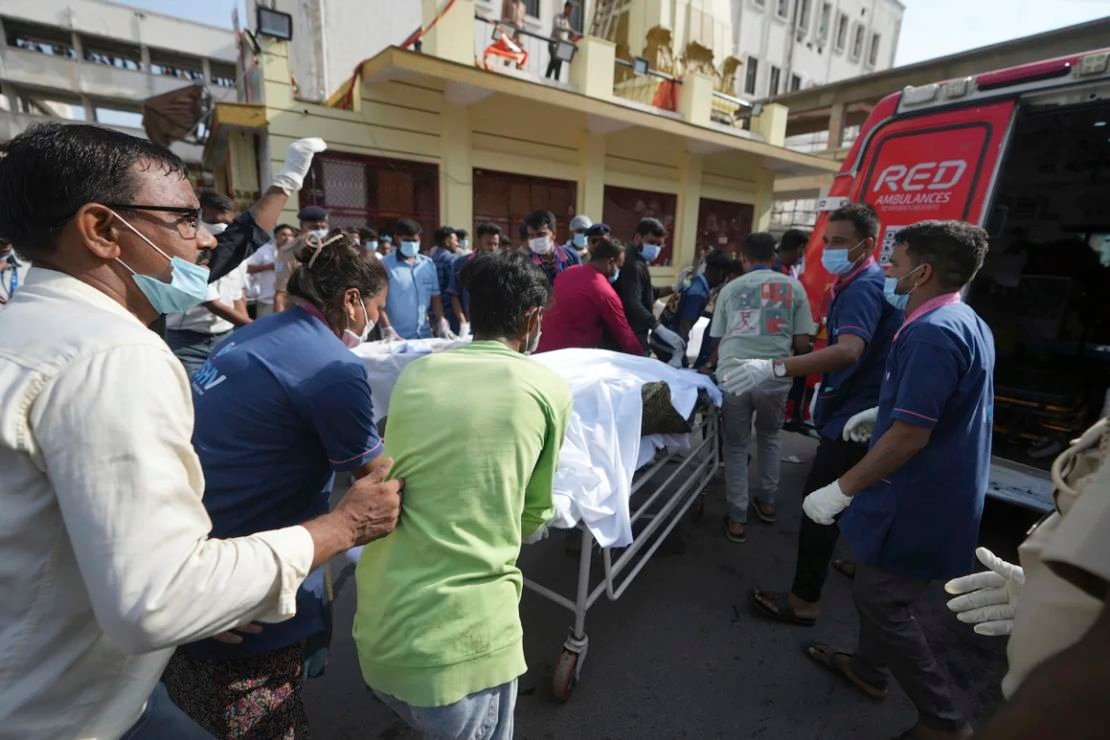 El cuerpo de una víctima es trasladado en camilla a una ambulancia cerca del lugar del accidente.